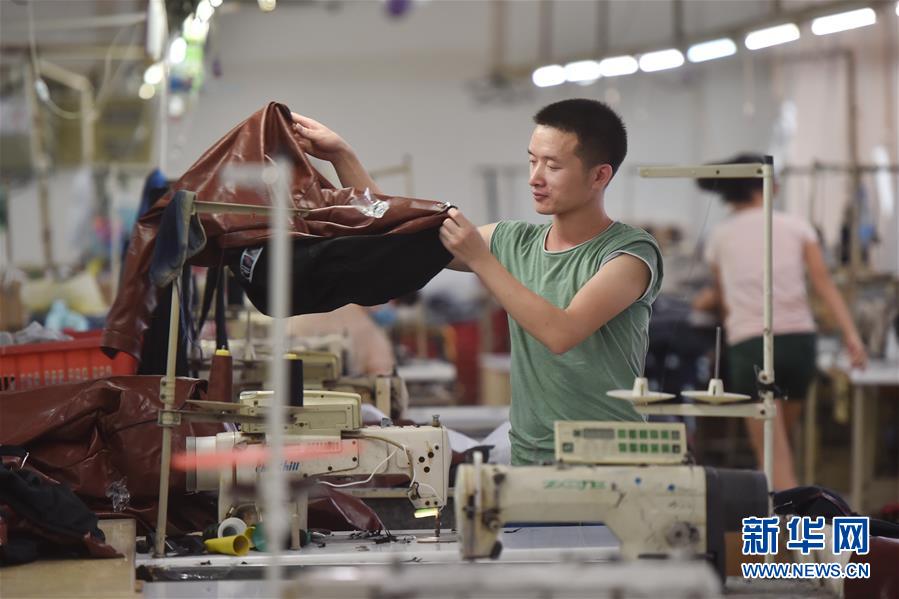 7月31日,在福建省石狮市一家服装厂,工人在加工秋冬订单服装.